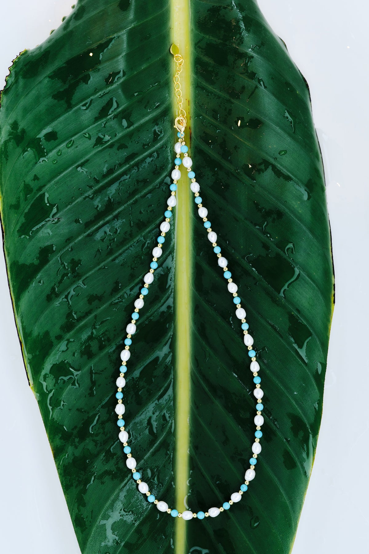 Fine Moonline Necklace with multitone freshwater pearls arranged on a green leaf