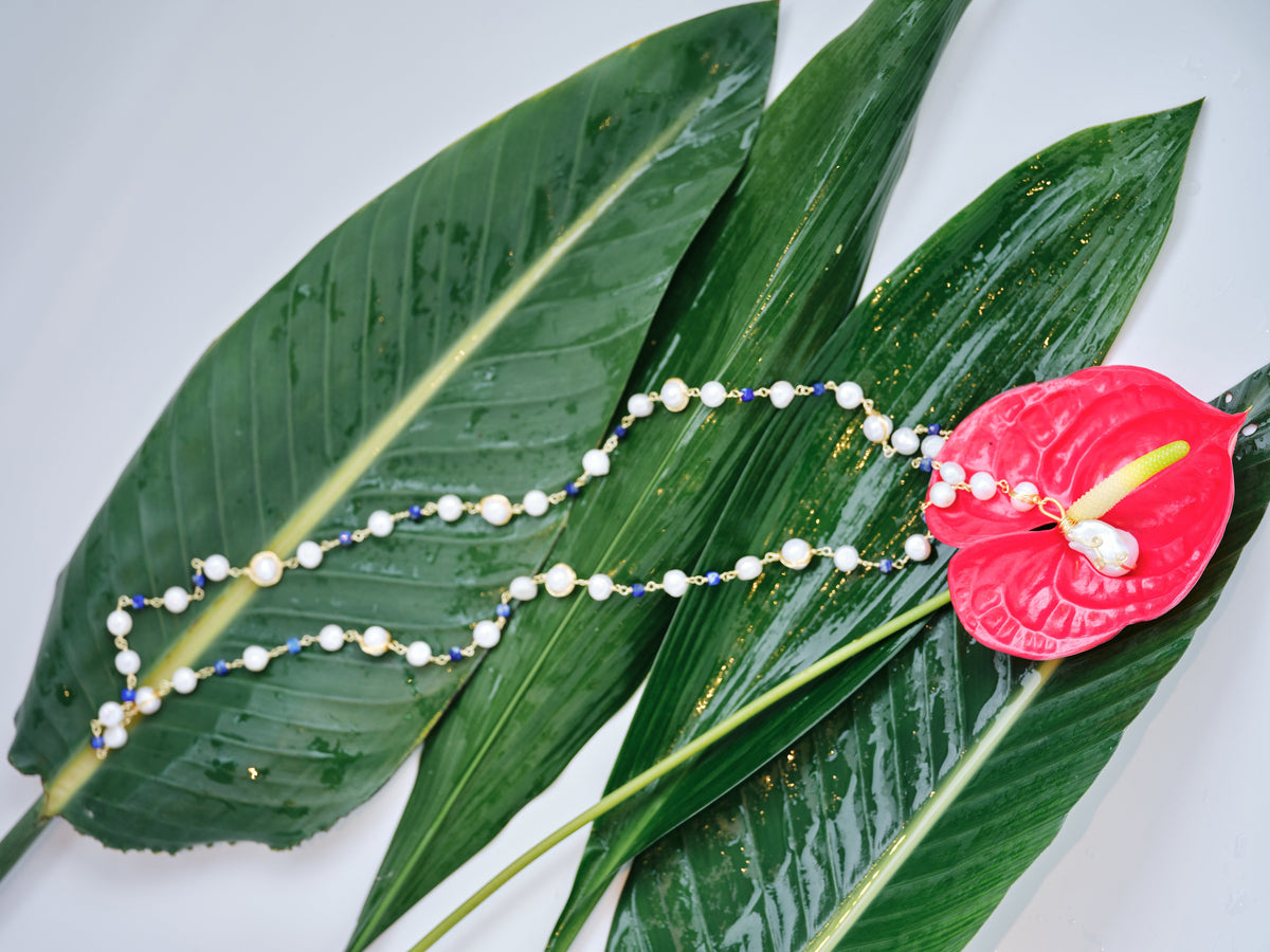 Chromatic Tide Pearl Necklace styled across tropical leaves and a red anthurium