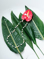 Chromatic Tide Pearl Necklace alternate styled view on layered green leaves