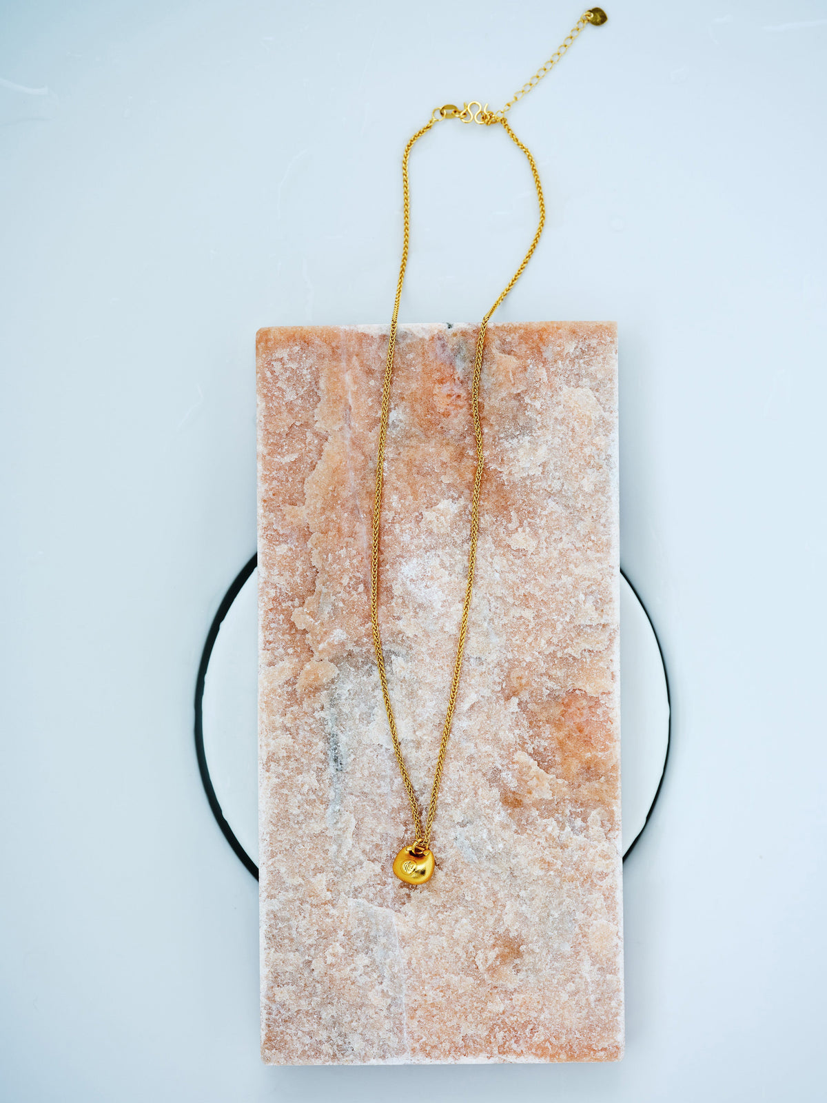 Golden Ingot Chain Necklace in 24K gold-plated copper with a small yuanbao pendant on pale stone.