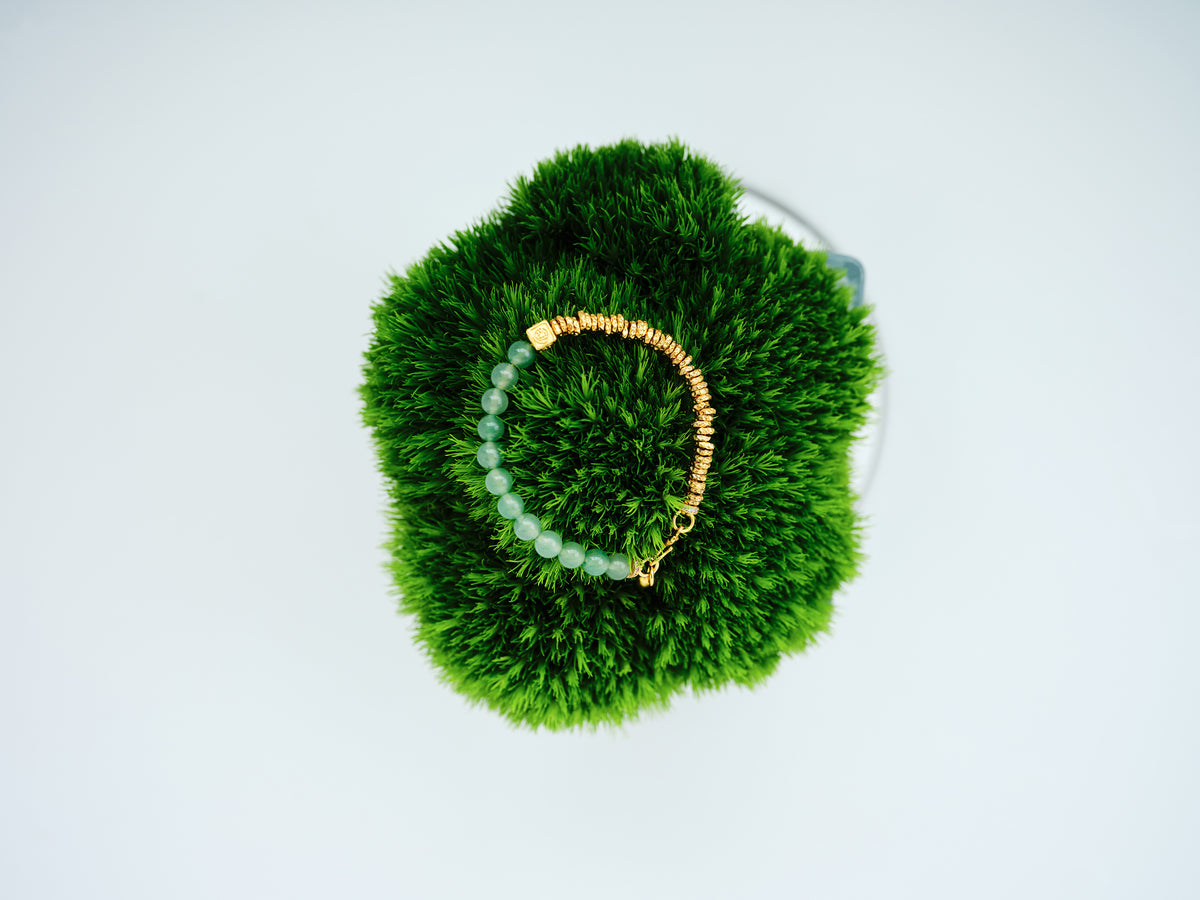 Seafoam Loop Bracelet with pale green-toned crystal beads and 24K gold-plated copper details on green moss.