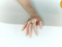 Layered pearl, lapis and silver-tone adjustable rings worn together on a hand