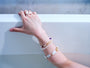 Silver-tone geometric bar and freshwater pearl adjustable ring worn with pearl bracelets