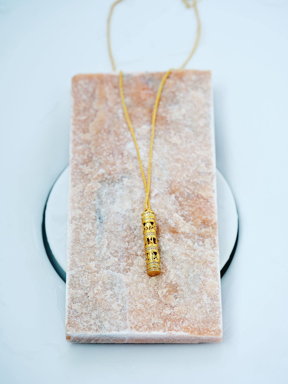 Gold-plated copper necklace with an ornate cylindrical pendant and clear crystal accents